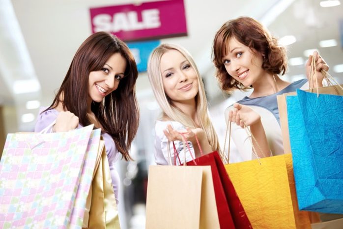 Three women shopping and holding shopping bags