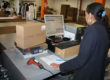 Wrap and Send employee working at scan and package station.