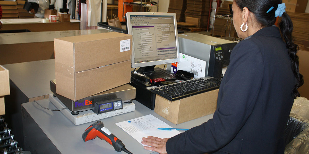 Wrap and Send employee working at scan and package station.