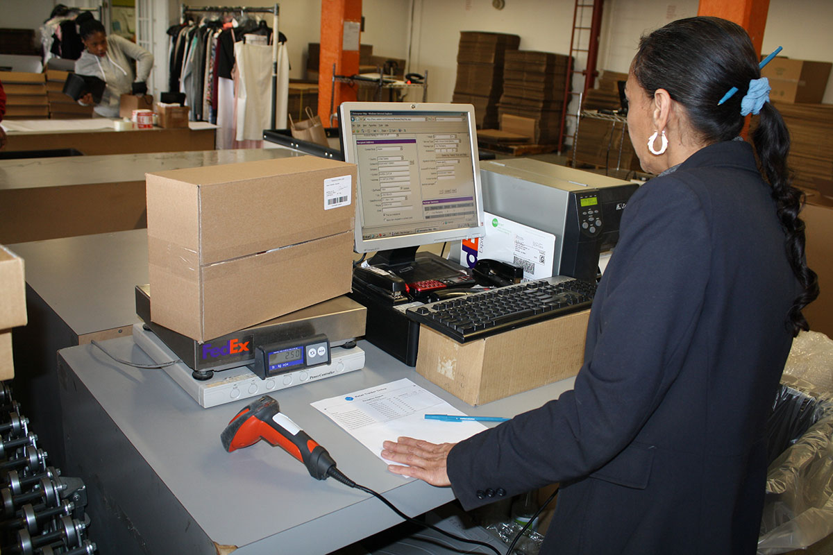 Wrap and Send employee working at scan and package station.