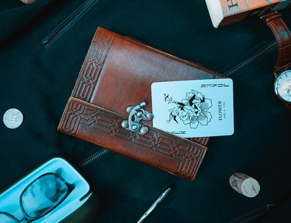 Joker playing card on top of high class notebook
