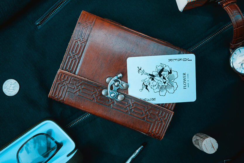 Joker playing card on top of high class notebook