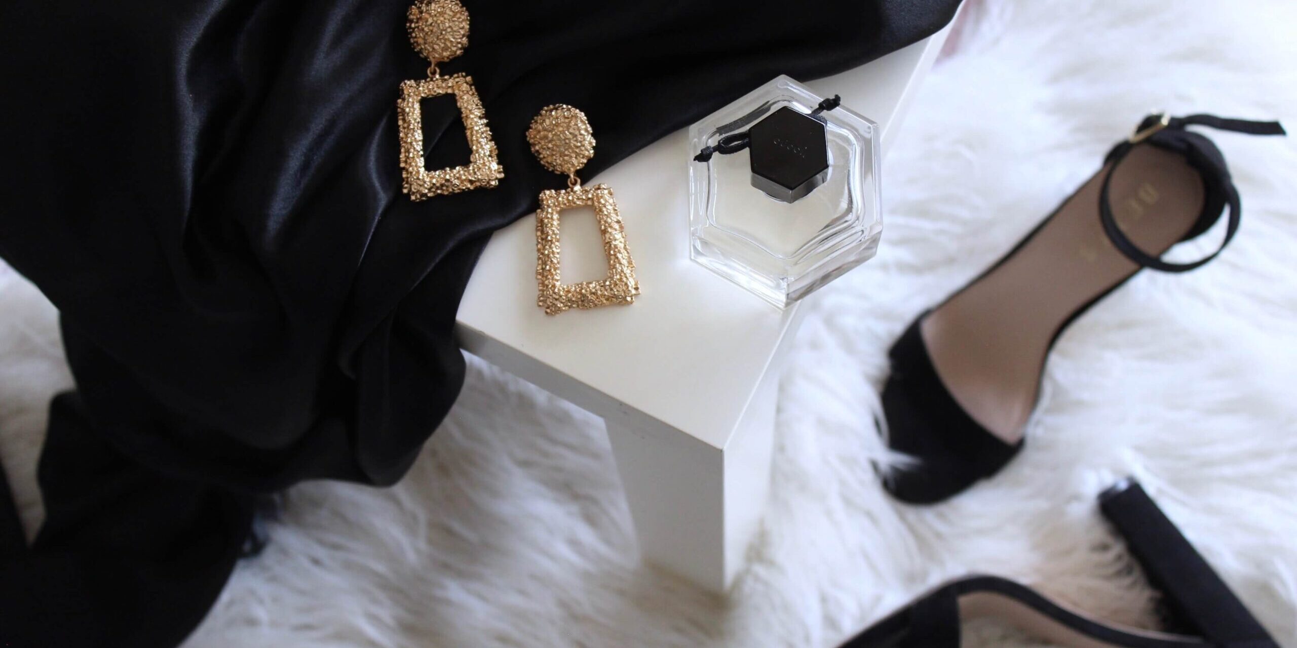 High fashion black pums, gold earrings and white fur
