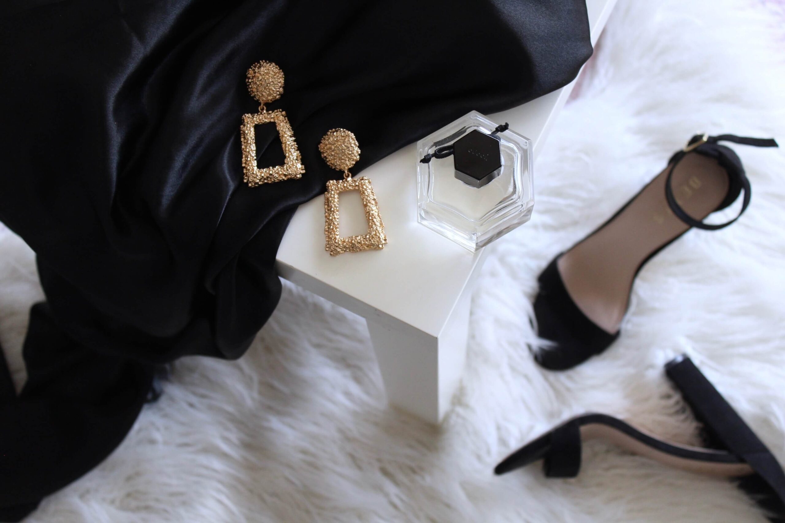 High fashion black pums, gold earrings and white fur