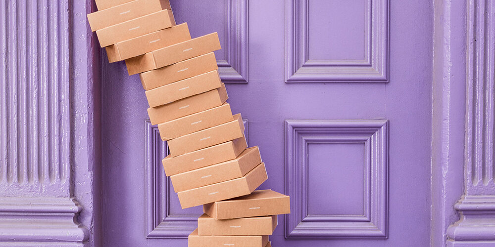 brown boxes stacked in front of a purple door