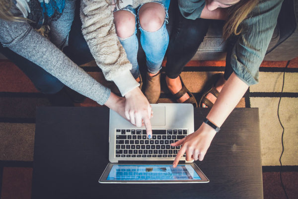 women pointing at a laptop screen