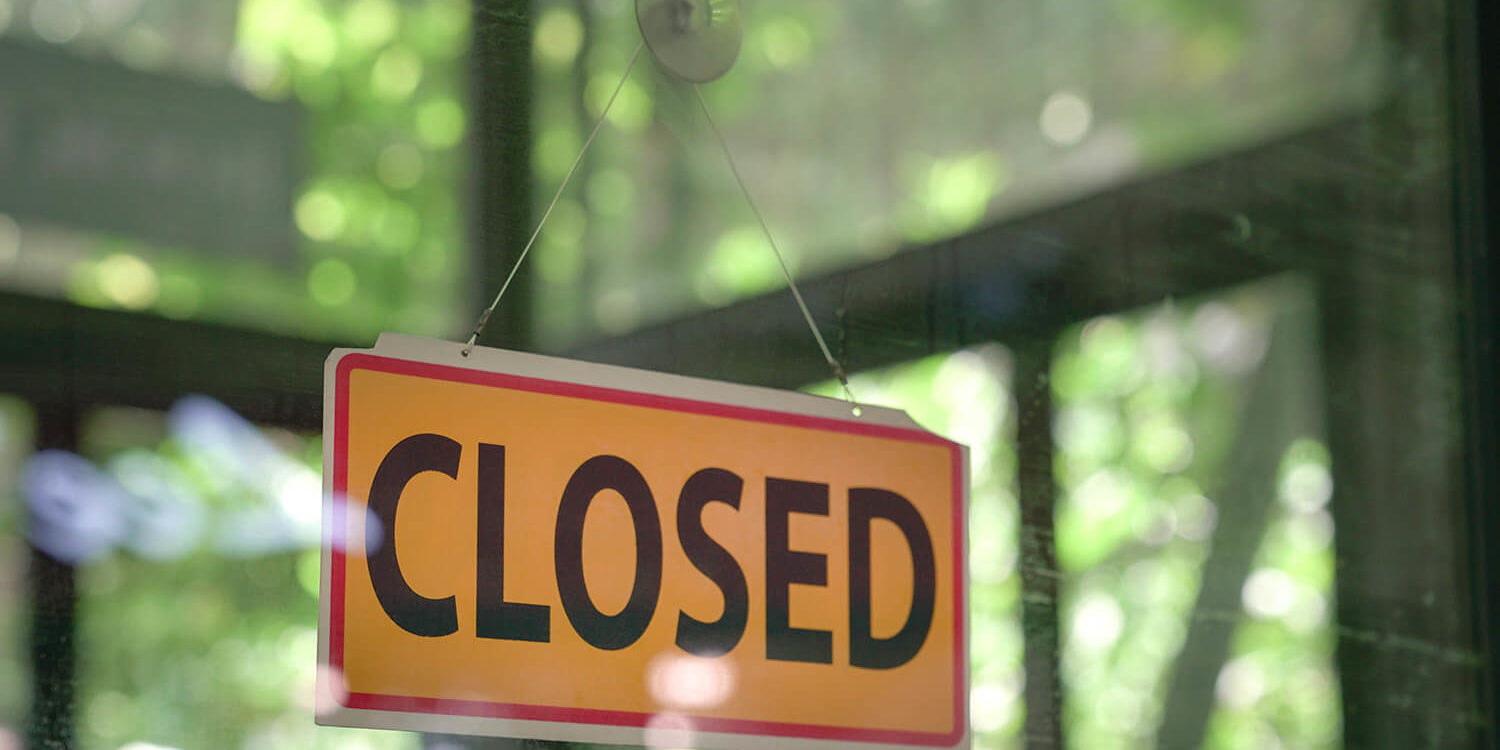 "Closed" sign hanging in a store window