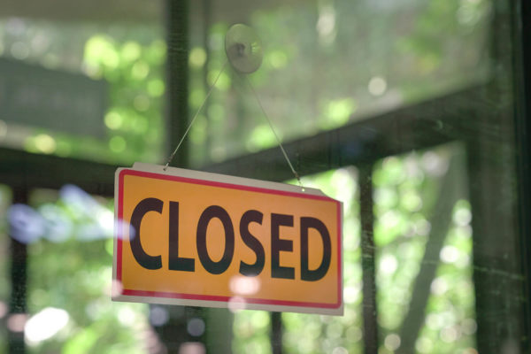 "Closed" sign hanging in a store window
