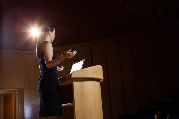 Female business executive giving a speech in an auditorium