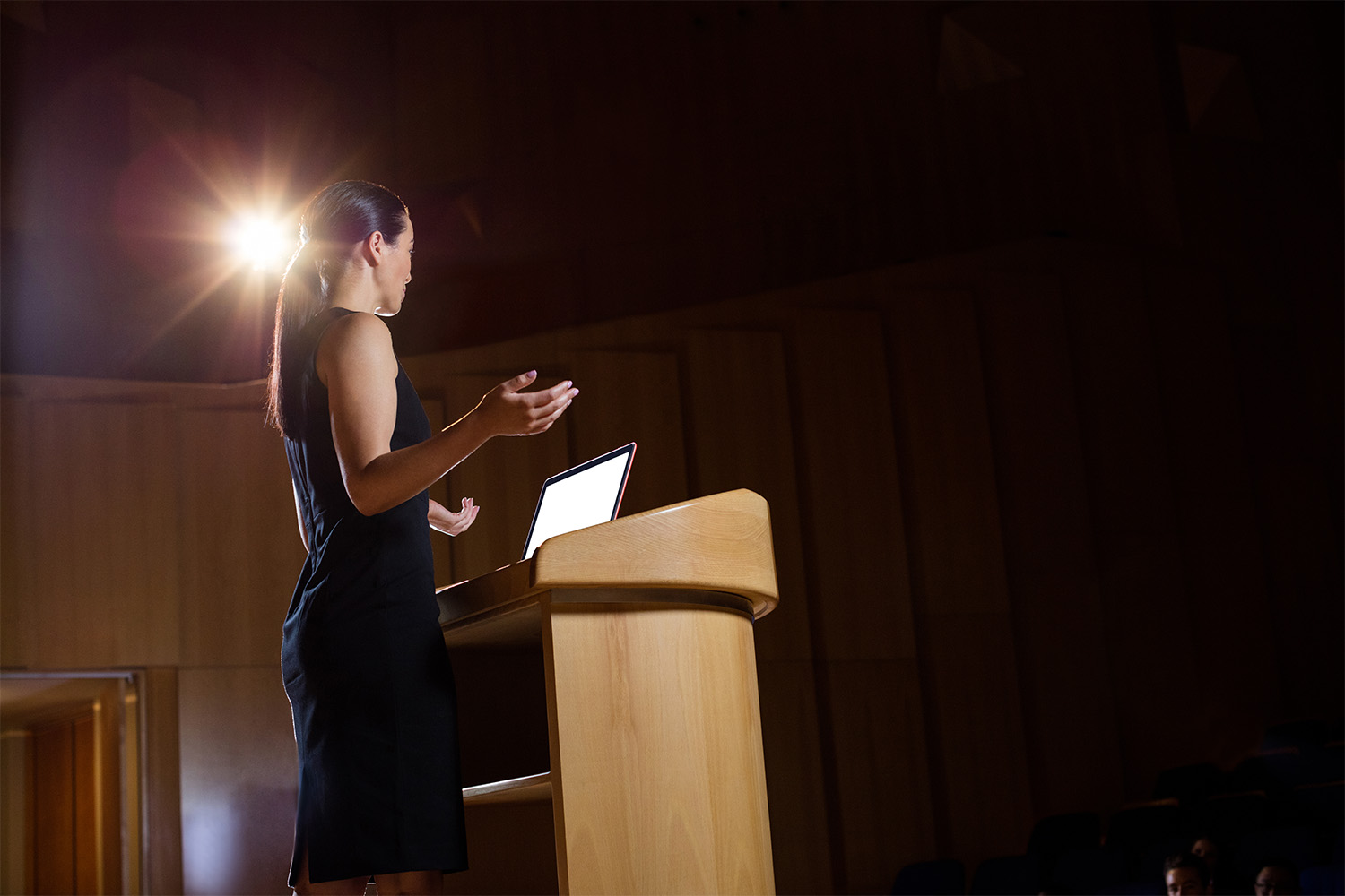 Female business executive giving a speech in an auditorium