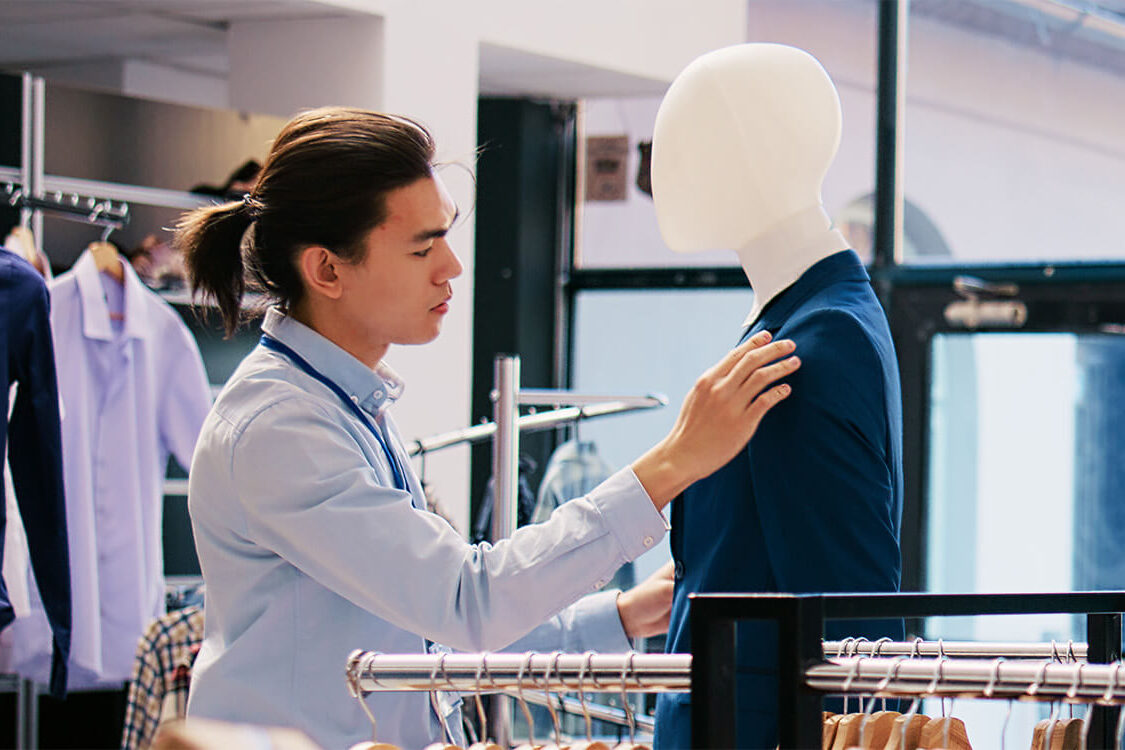 Man inspecting a blue suit in a store