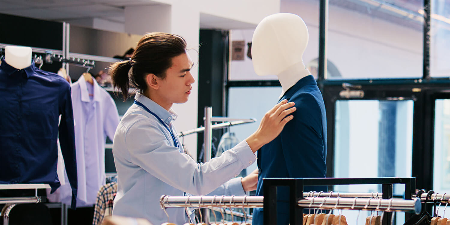 Man inspecting a blue suit in a store