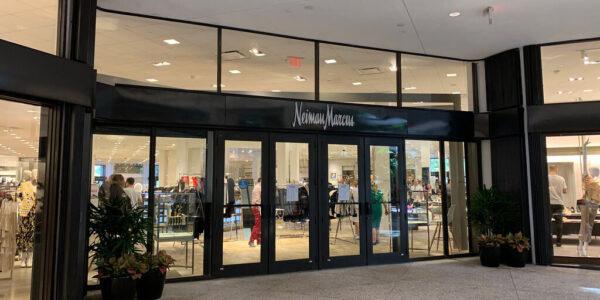 Outside a Neiman-Marcus store with windows looking in at luxury clothing for sale