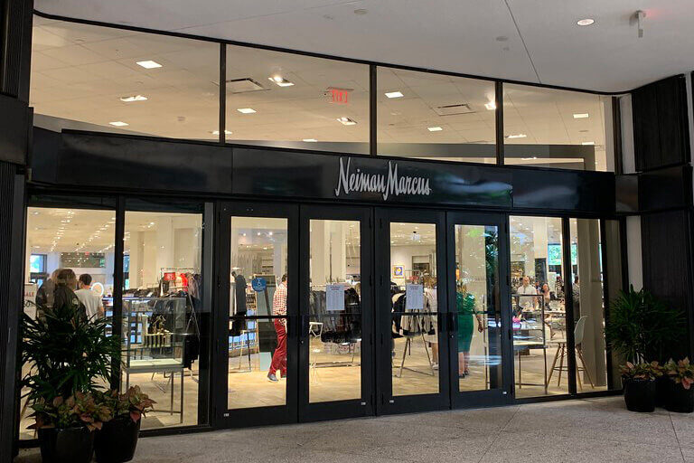 Outside a Neiman-Marcus store with windows looking in at luxury clothing for sale